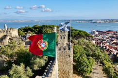 The photo presents the Portuguese flag with Lisbon in the background.