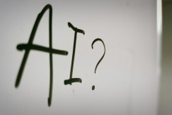 The photo presents “AI?” written on a whiteboard.