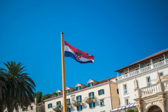 The photo presents the Croatian flag in front of a building.