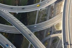 The image shows an aerial view of a ring road interchange, featuring interconnected roadways designed to facilitate traffic flow across the transport network.