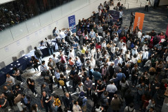 The photo presents a crowded networking event.