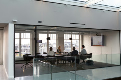 The photo presents a business meeting in a conference room.