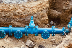 The image shows a newly installed water pipeline within an excavation trench, illustrating the modernisation of underground water distribution infrastructure.
