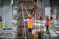 The picture shows construction workers carrying out building activities on an active construction site.