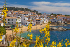 The photo presents a coastal town with a sandy beach.