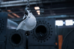 The photo presents a safety helmet hanging inside an industrial facility.