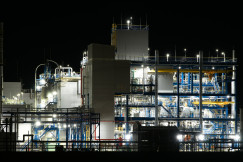 The photo presents an industrial facility illuminated at night.
