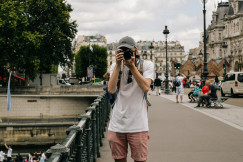 The photo presents a tourist taking a photo in Paris.