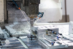 The photo presents a machine cutting metal.