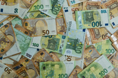 The photo presents scattered euro banknotes.