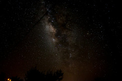The photo shows the Milky Way in a star-filled night sky.