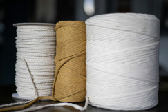 Three spools of twine are sitting on a table.