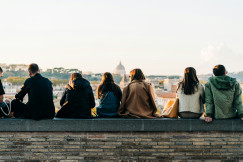 The photo shows tourists and locals mingle at sunset in Giardino degli Aranci in Rome, Italy