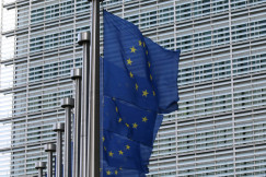 Blue EU flag on pole near building during daytime.