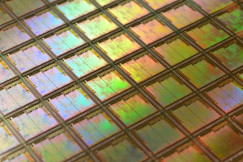 The photo presents a silicon wafer with computer chips.