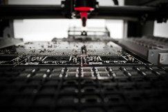 The photo presents a machine producing circuit boards.