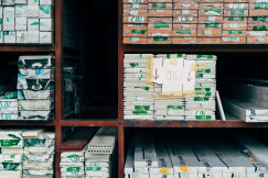 The picture shows stacks of construction and insulation materials neatly stored on industrial warehouse shelving.