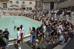The photo shows tourists around the Trevi Fountain in Rome, Italy.