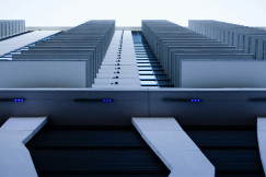The picture describes a modern high-rise building viewed from below.