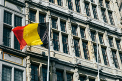 The photo presents the Belgian flag in front of a building.