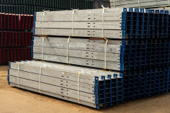 The picture describes stacks of prefabricated steel components stored in an industrial yard for use in construction projects.