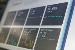 The photo presents data charts and statistics on a screen.