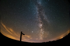 The photo shows the Milky Way over a dark landscape.                Is this conversation helpful so far?