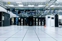 The photo presents a data centre with server racks.