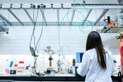 The photo presents a scientist working with equipment in a laboratory.