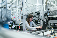 The photo presents an engineer working on a laptop.