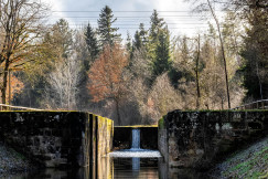 The picture describes a concrete water management structure with large openings above a body of water.