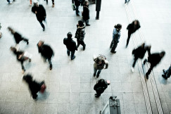 The photo shows people walking through a busy public space.