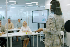 Woman presenting to an attentive audience in a modern office