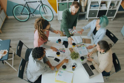 The picture shows a team collaboration meeting in a creative office environment.