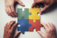 Hands assembling a colorful puzzle