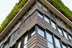 This picture shows a modern multi-story building photographed from a low-angle perspective, emphasizing its height and architectural design.
