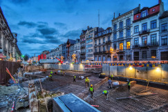 This picture depicts a large urban construction site situated in the middle of a city street.