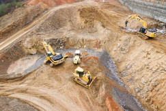 This picture shows heavy construction machinery, including excavators and a bulldozer, carrying out excavation and earthmoving work at a construction site.This picture shows heavy construction machinery, including excavators and a bulldozer, carrying out excavation and earthmoving work at a construction site.