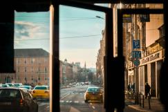 An illustrative photo of vehicles on road beside buildings.