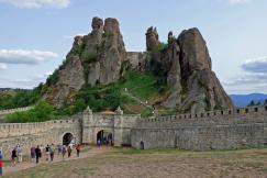 An illustrative photo of a historical fortress with stone walls and an arched entrance gate