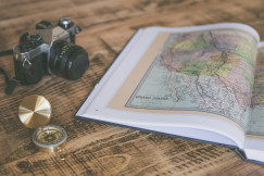 An illustrative photo of a compass and map laid out on a table.