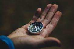 An illustrative photo of a hand holding a compass