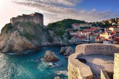 An illustrative photo of a coastal scene with a fortified city