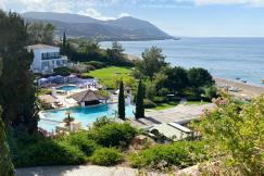 An illustrative photo of a coastal resort with white buildings and swimming pool 