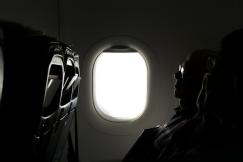 An illustrative photo of two person sitting inside of airplane.