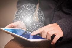 An illustrative photo of a person seated and using a tablet