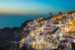 An illustrative photo of white and brown concrete houses on mountain.