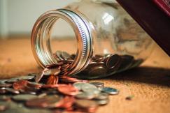 An illustrative photo of a clear glass jar filled with an assortment of coins