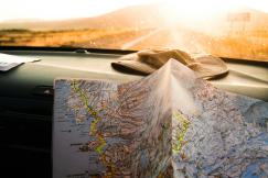 An illustrative photo of a person holding a map in a car