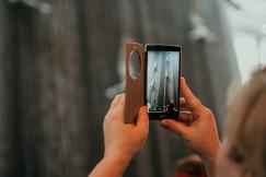 An illustrative photo of a woman taking a picture with her cell phone